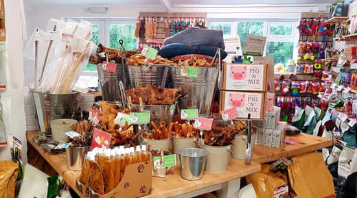 Brown wooden bird feeder with hanging hook and metal perch for dog treats