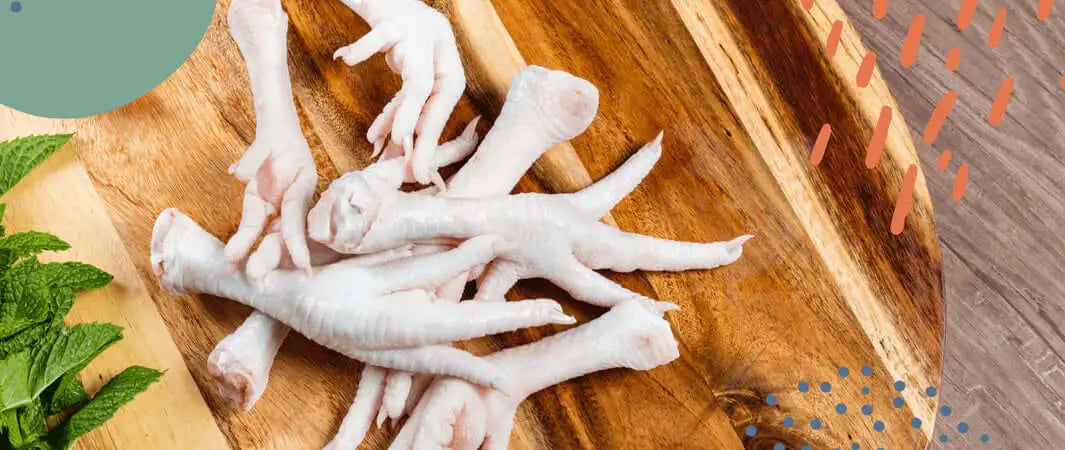 Grain free chicken feet dog treat on wooden board with mint and carrots