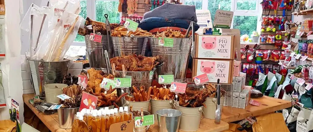 Wooden dog treat pick n mix display with metal baskets and pink tags