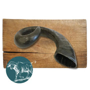 Black curved buffalo horn on wooden surface, natural dog chew