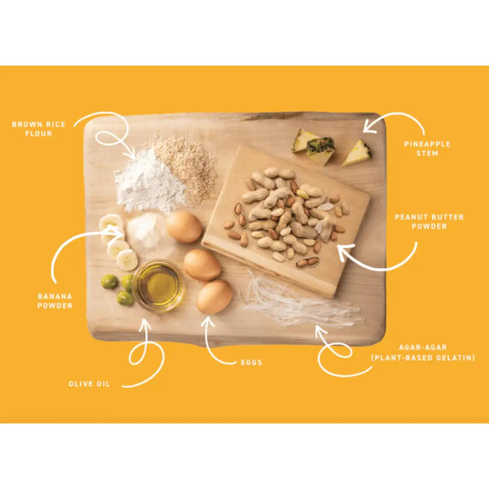 Earth Animal No-Hide peanut butter medium chews with nuts and dried fruits on wooden board