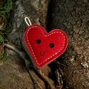 Red love heart made felt ornament with black eyes, smiling mouth, hanging from white string, Green And Wilds Trudy Truelove Eco Toy