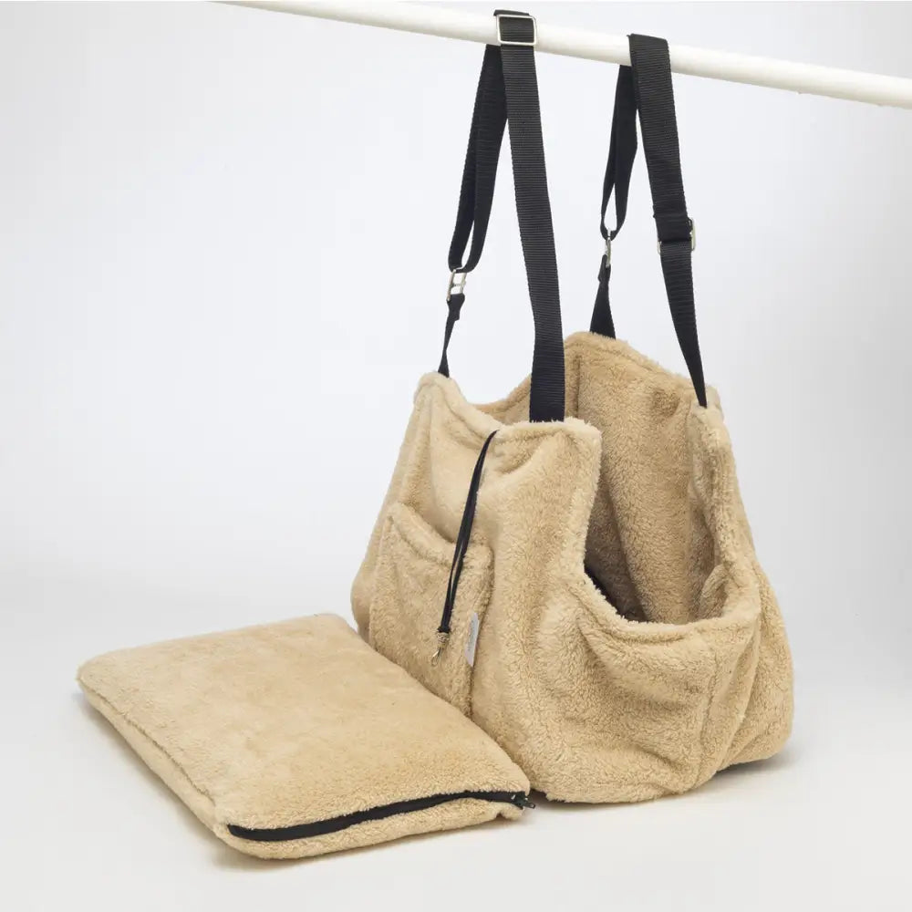 Beige sherpa tote bag with black straps and zipper closure, ideal as a teddy bear dog carrier