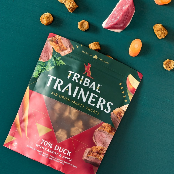 Tribal Trainers air dried meaty treats packaging on a teal background with treats around it.