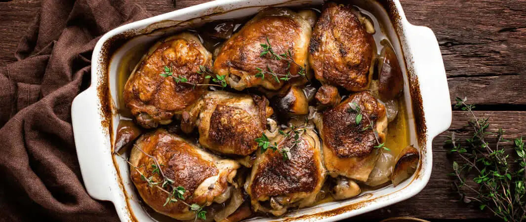 Roasted chicken thighs in ceramic dish, a staple ingredient for dog foods