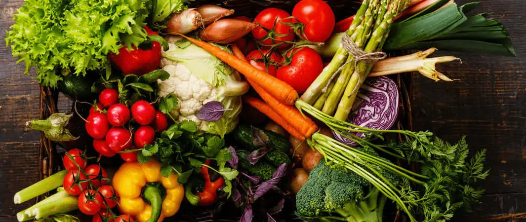 Multi-colored fresh vegetable assortment on wooden surface for Mighty Mussel Munchies.