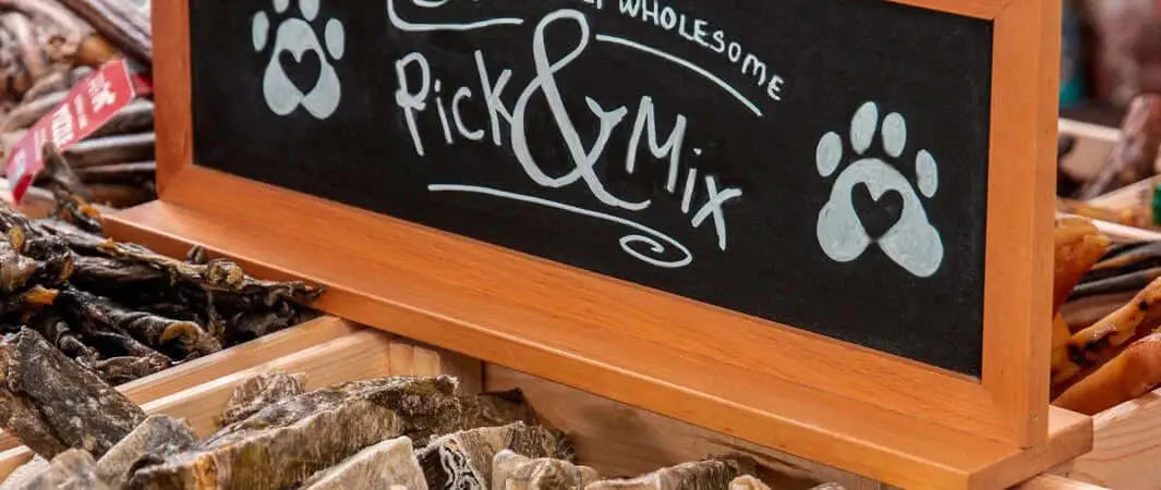 Black chalkboard sign with paw prints and wooden frame for safe dog chews