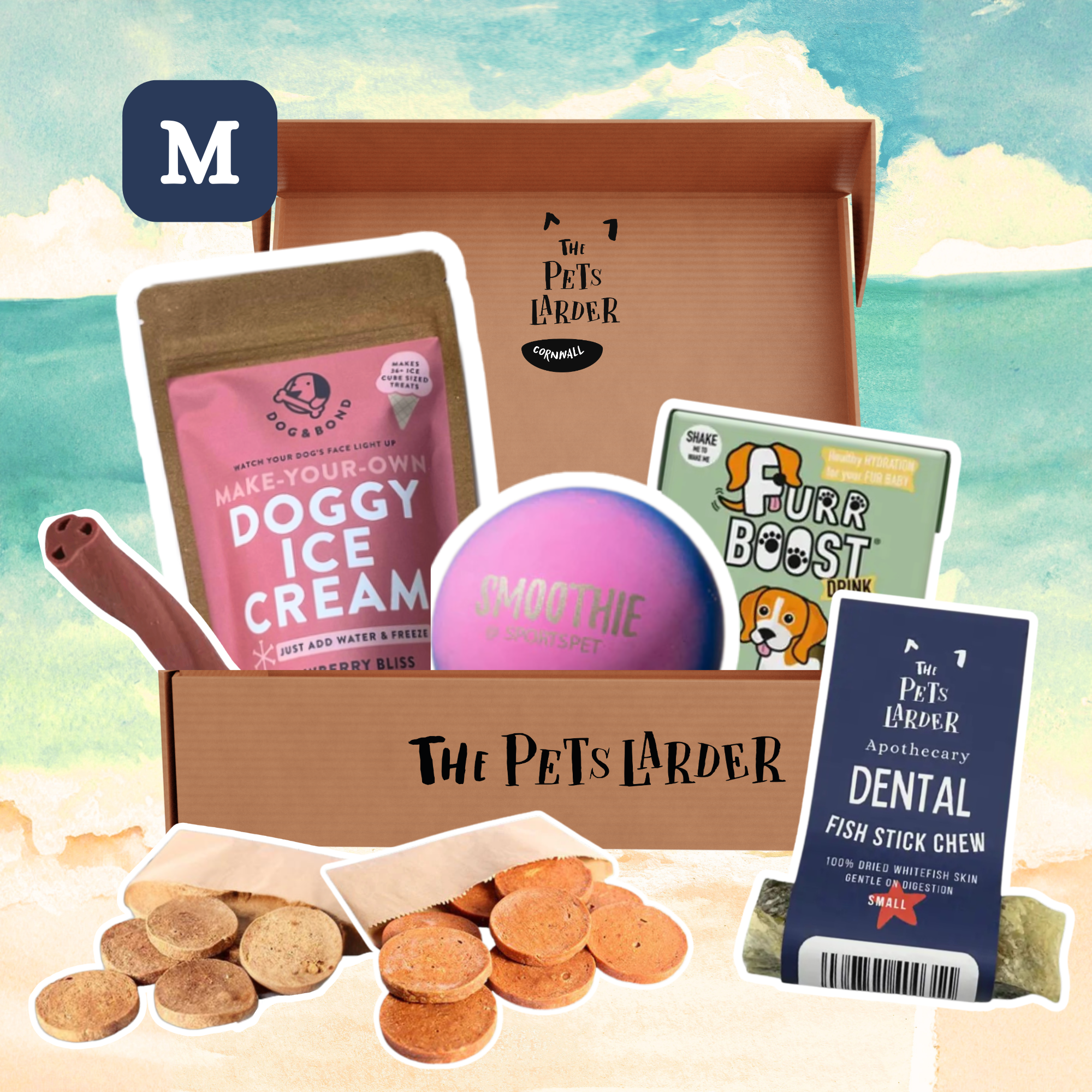 Doggy care package from The Pets Larder with various pet products on a beach background.