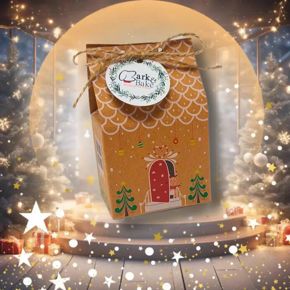 Golden gift box with reindeer, Christmas tree, and Clark Bake logo for mini gingerbread hoomans