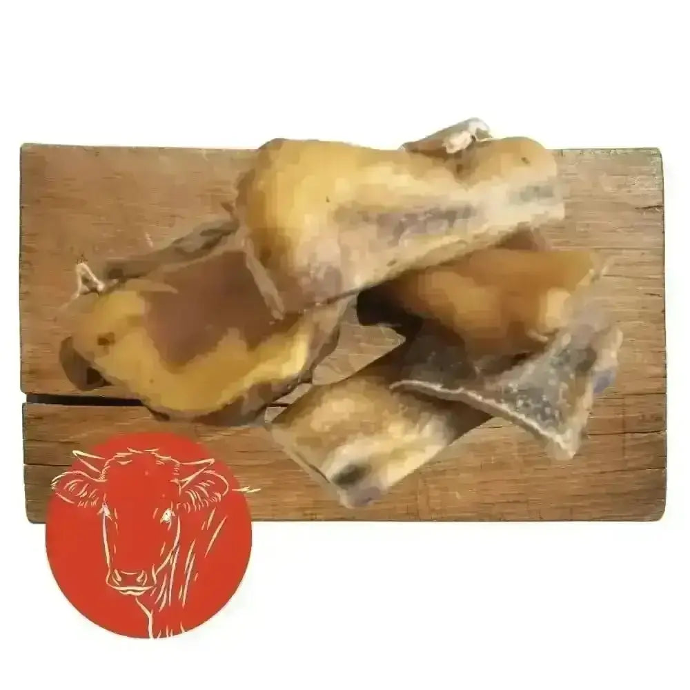 Beef muscle chew toy with goat bone on wooden board and cow logo