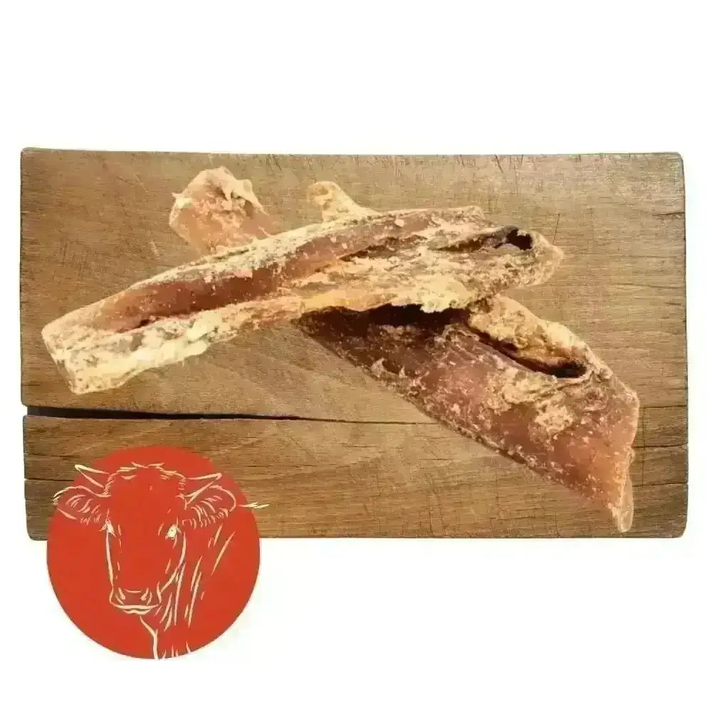 Beef neck tendon jerky sticks on wooden board with red cow logo