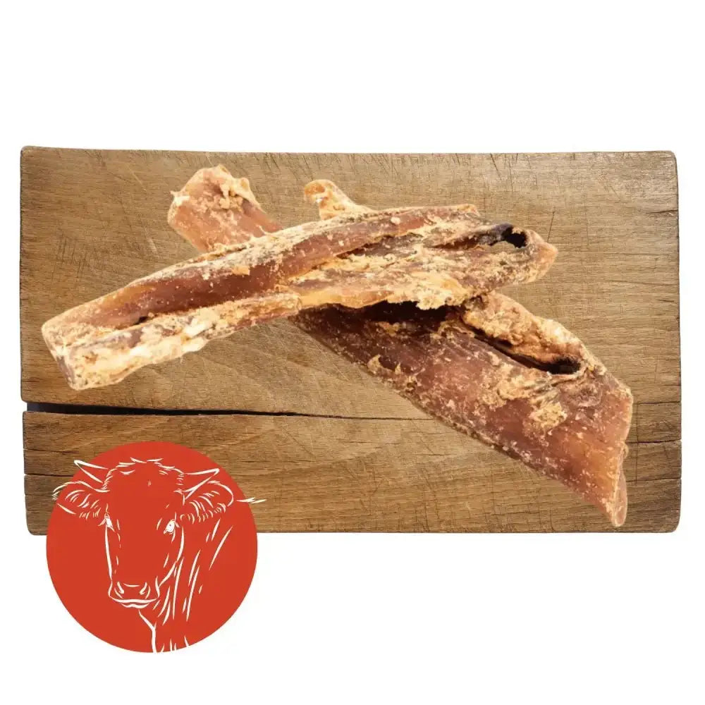 Beef neck tendon jerky sticks on wooden board with red cow logo