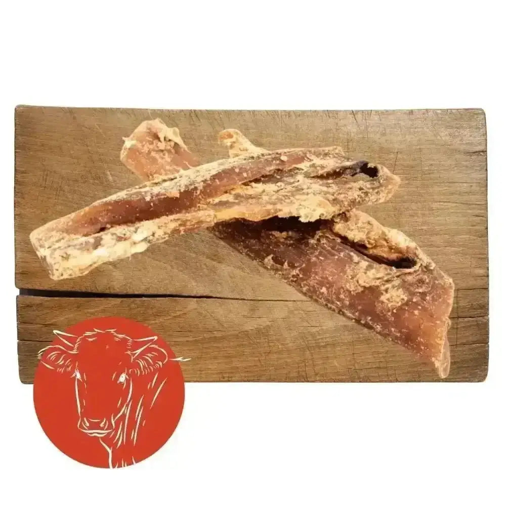 Beef neck tendon jerky sticks on wooden board with red cow logo
