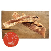 Leather jerky sticks with red cow logo on wooden board, ideal beef neck tendon dog chew