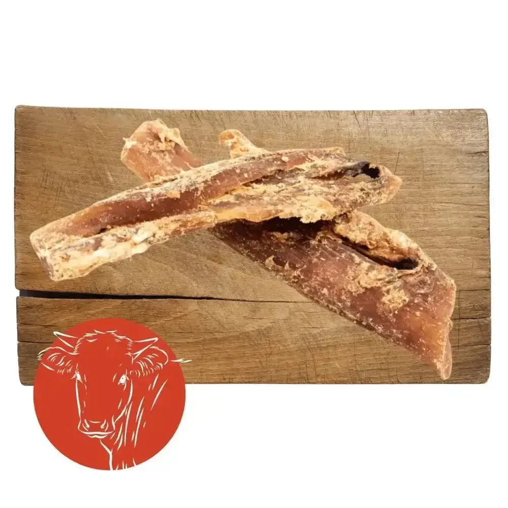 Leather jerky sticks with red cow logo on wooden board, ideal beef neck tendon dog chew