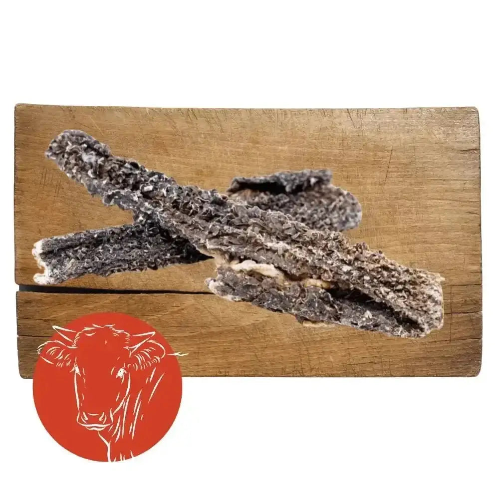 Charcoal-colored beef tripe natural dog chew on wooden board