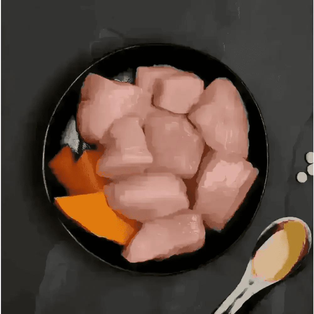 Canagan cat food can with raw chicken and pumpkin on black plate