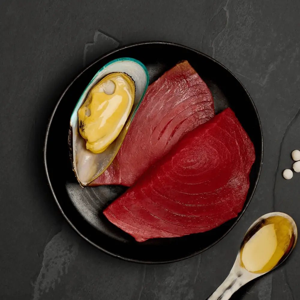 Black plate with raw tuna, mussel shell, and honey for Canagan Cat Food Can Tuna with Mussels
