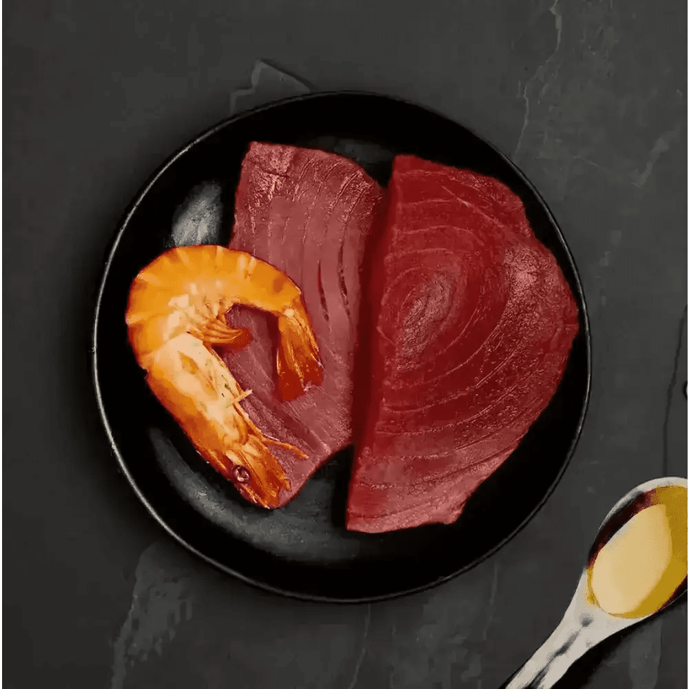 Black plate with raw tuna and prawns, oil-filled spoon, ideal for Canagan Cat Food Can