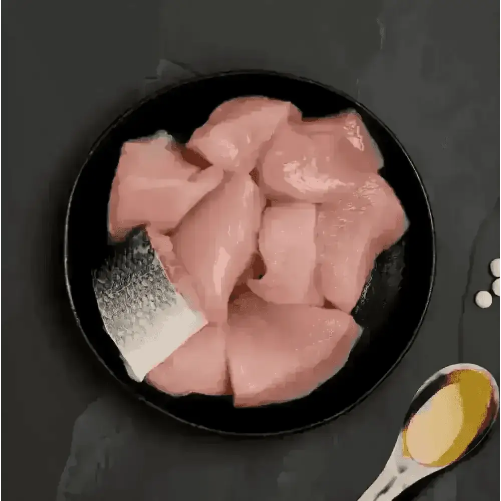 Black plate with raw fish slices and oil, ideal as highly nutritious complete cat food to accompany dry food