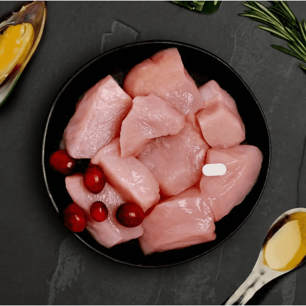 Canagan cat pouch with fresh chicken, cranberries on black plate
