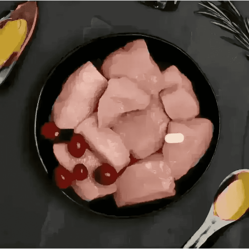 Canagan cat pouch with fresh chicken, cranberries on black plate