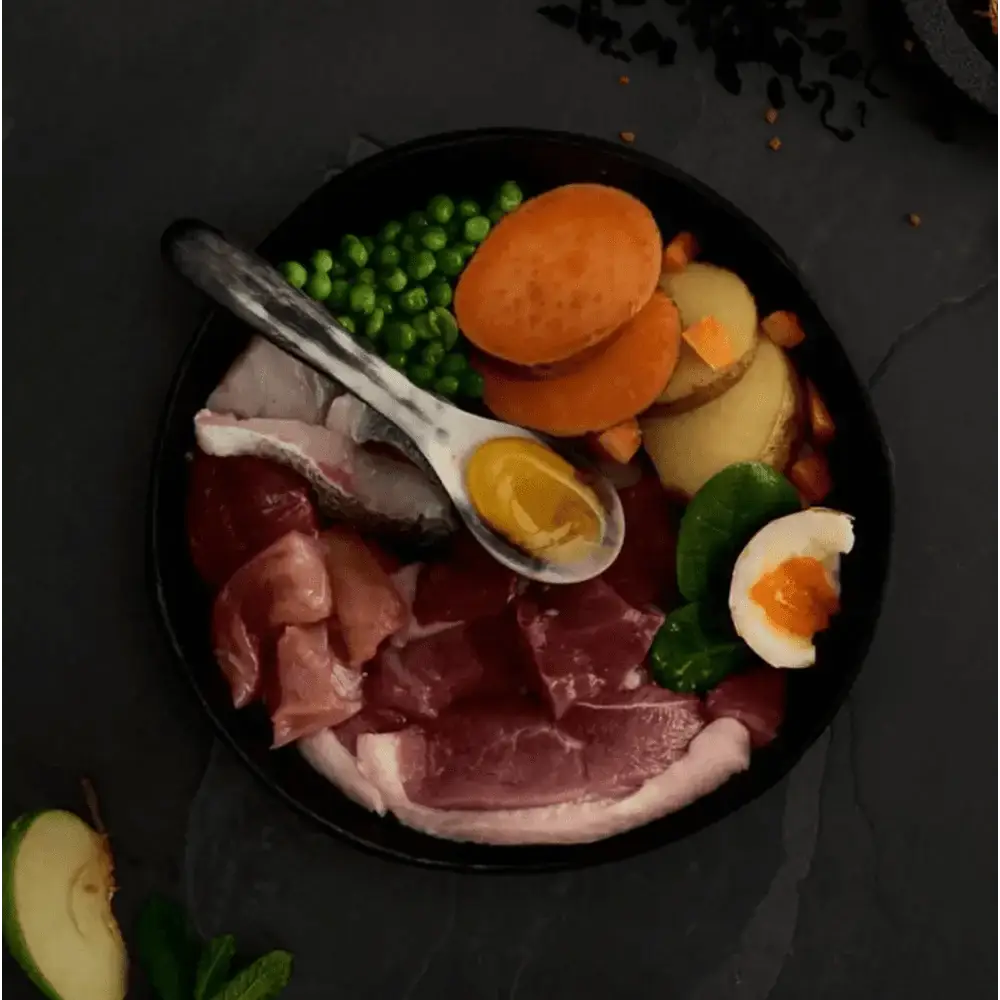 Canagan Country Game dog food in black bowl with duck, meats, veggies, eggs