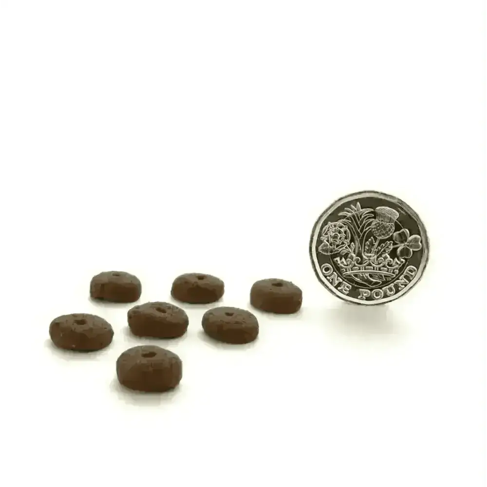 Chocolate donut-shaped dog treats with a hole, part of Canagan Dry Dog Food Small Breed Dental featuring Proden PlaqueOff® for oral health