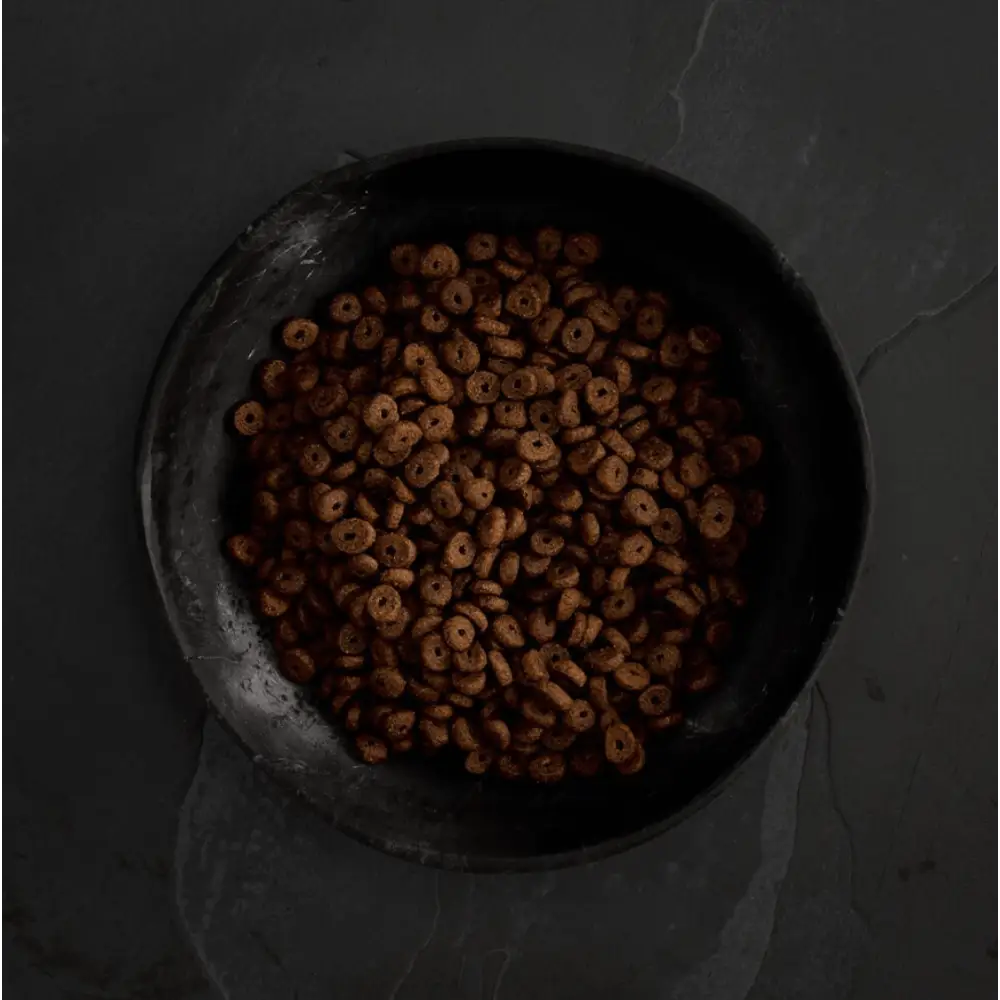 Chocolate-flavored cereal in a black bowl, part of Canagan Dry Dog Food Small Breed Dental with Proden PlaqueOff® for dogs