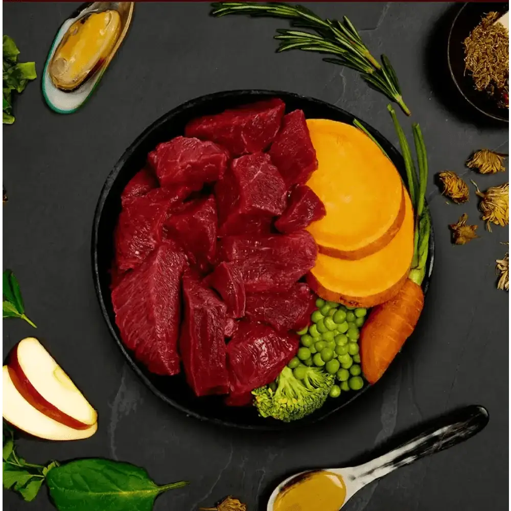 Black bowl with raw beef, vegetables, and spices for Canagan Wet Dog Food Beef Stew