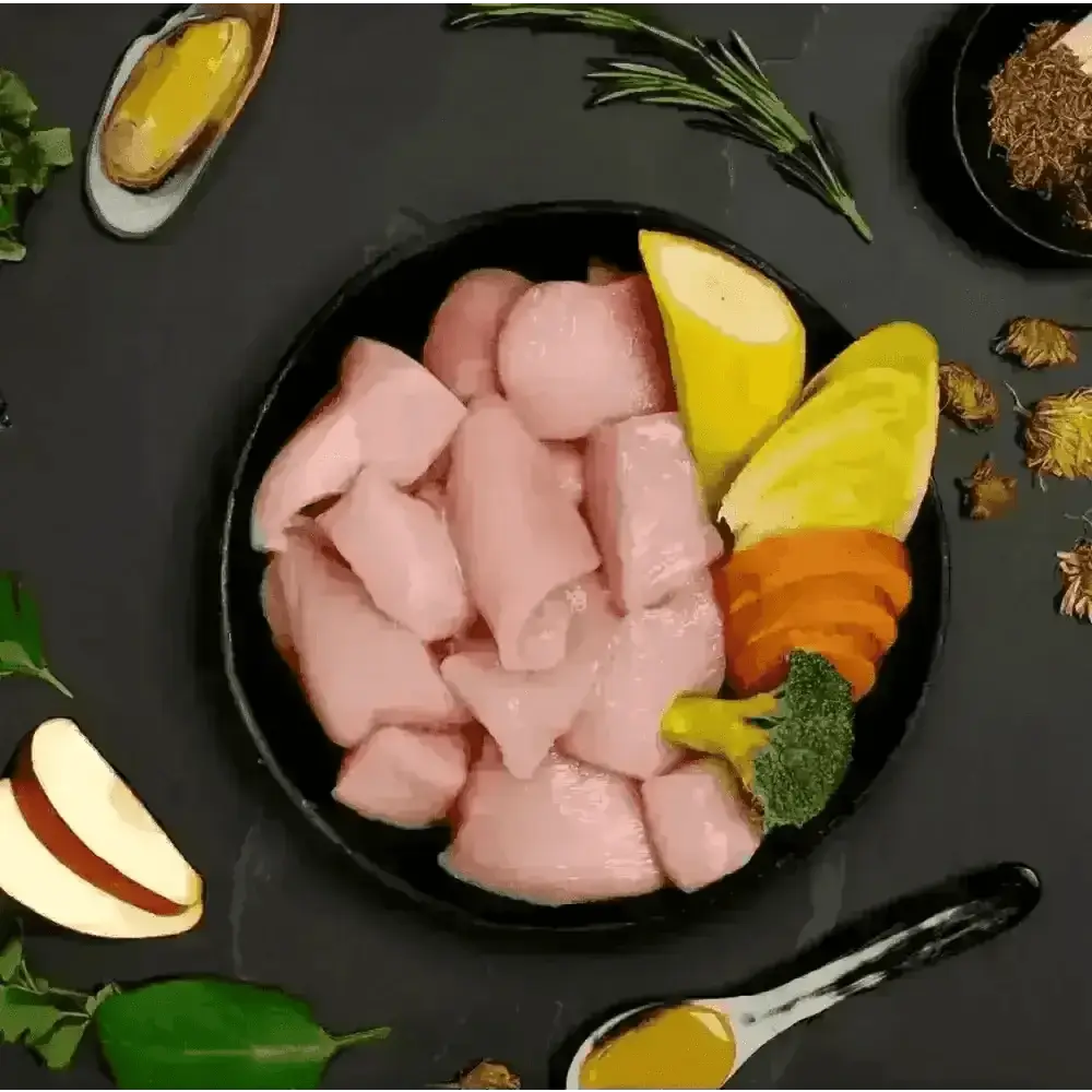 Black bowl with raw free run chicken, lemon slices, herbs, and spices for dog food
