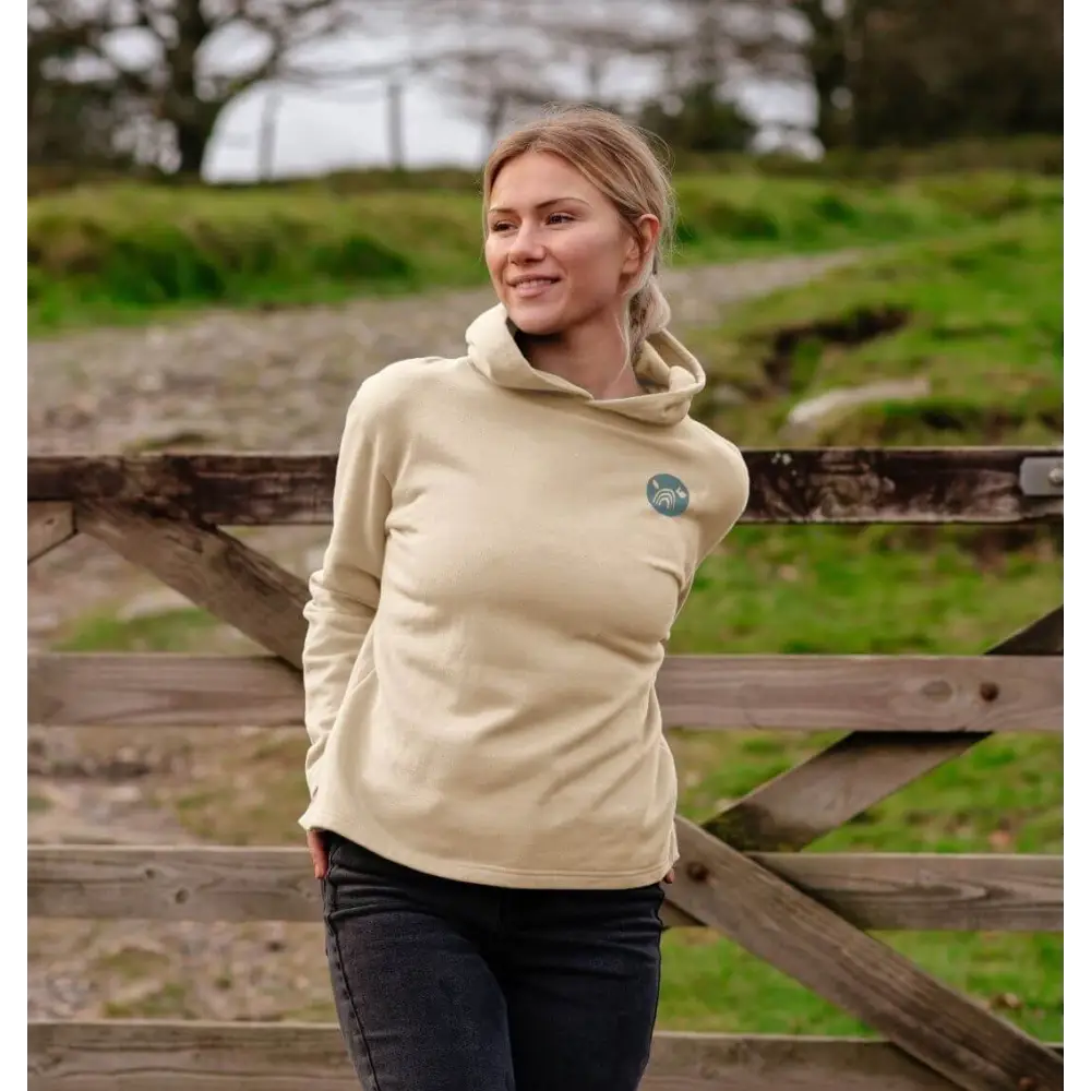 Beige certified organic cotton hooded sweatshirt with green logo and dark blue jeans