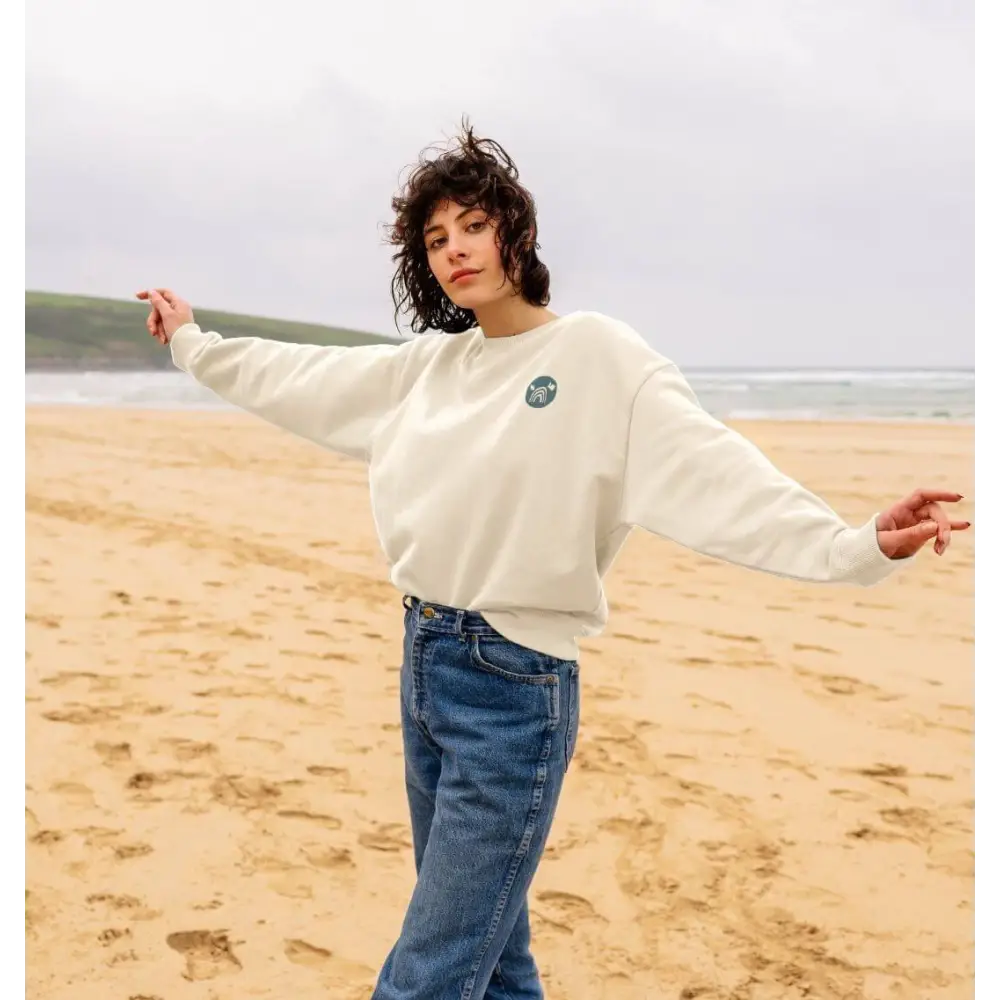 Certified organic cotton oversized women’s NCP logo jumper in cream with blue jeans