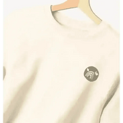 Certified organic women’s oversized NCP logo jumper in cream with teal design