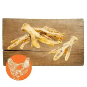 Bone-shaped chicken foot natural dog chew treats on wooden surface for dogs