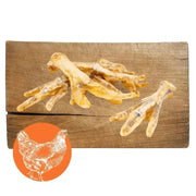 Bone-shaped chicken foot natural dog chew treats on wooden surface for dogs