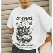 White organic cotton T-shirt with black raccoon and cat illustration and drive peace wild slogan