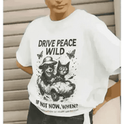 White organic cotton T-shirt with black raccoon and cat illustration and drive peace wild slogan