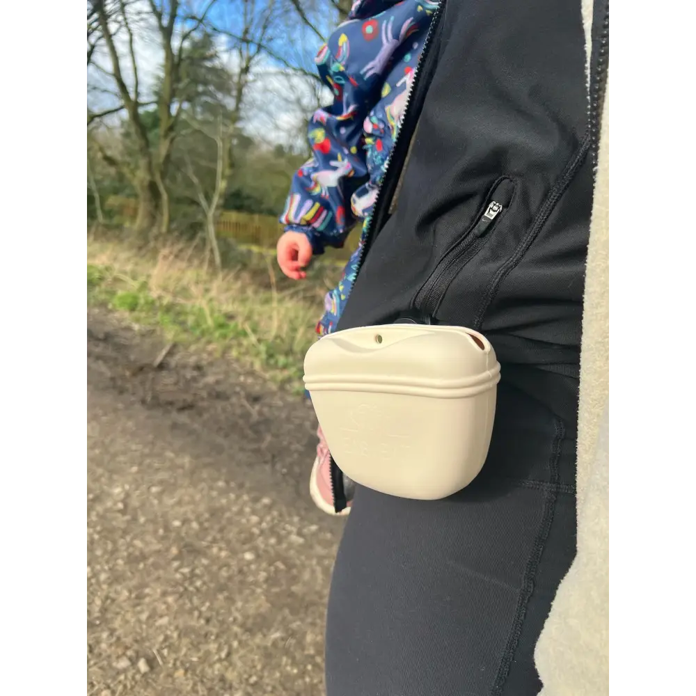 Cream-colored silicone dog treat bag with molded plastic bowl