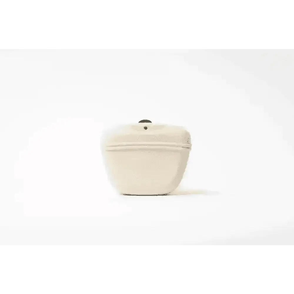 Cream-colored silicone dog treat bag with sleek curve and black top button