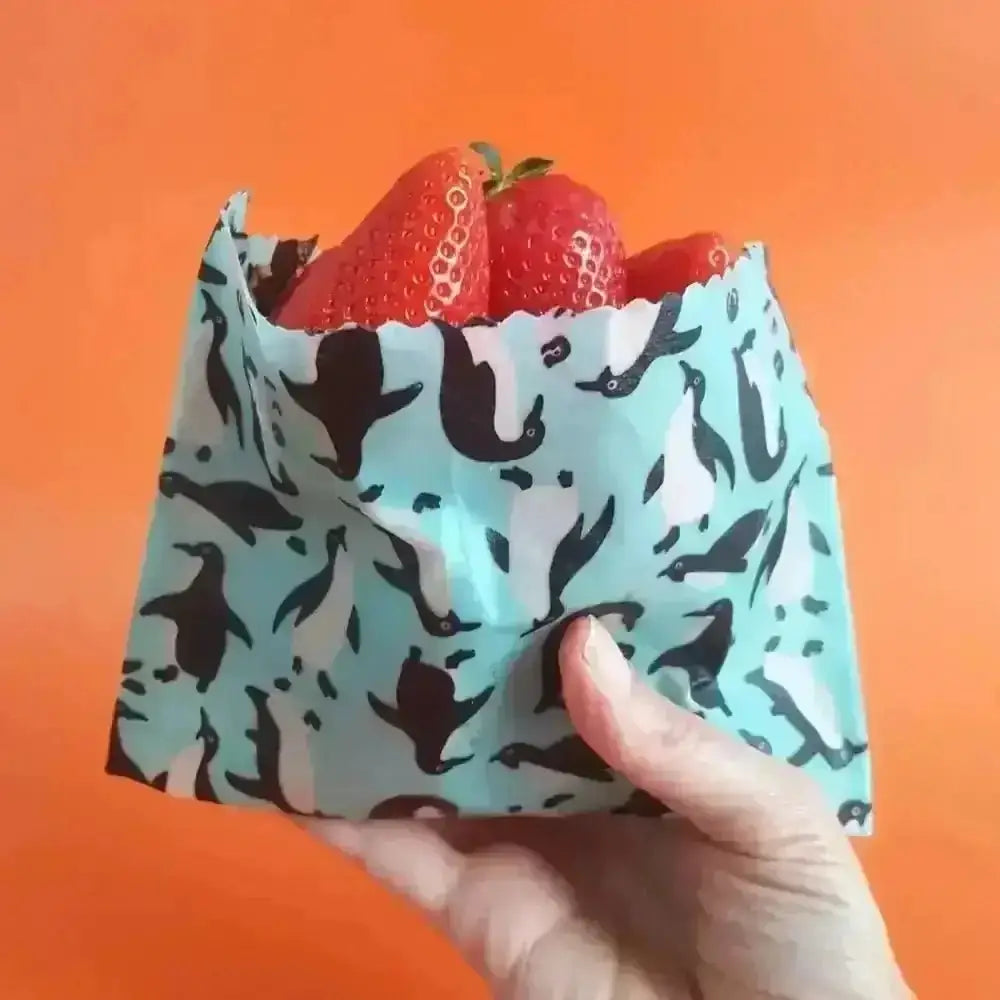 Teal penguin snack bag with strawberries in Honey Bee Good’s eco wraps