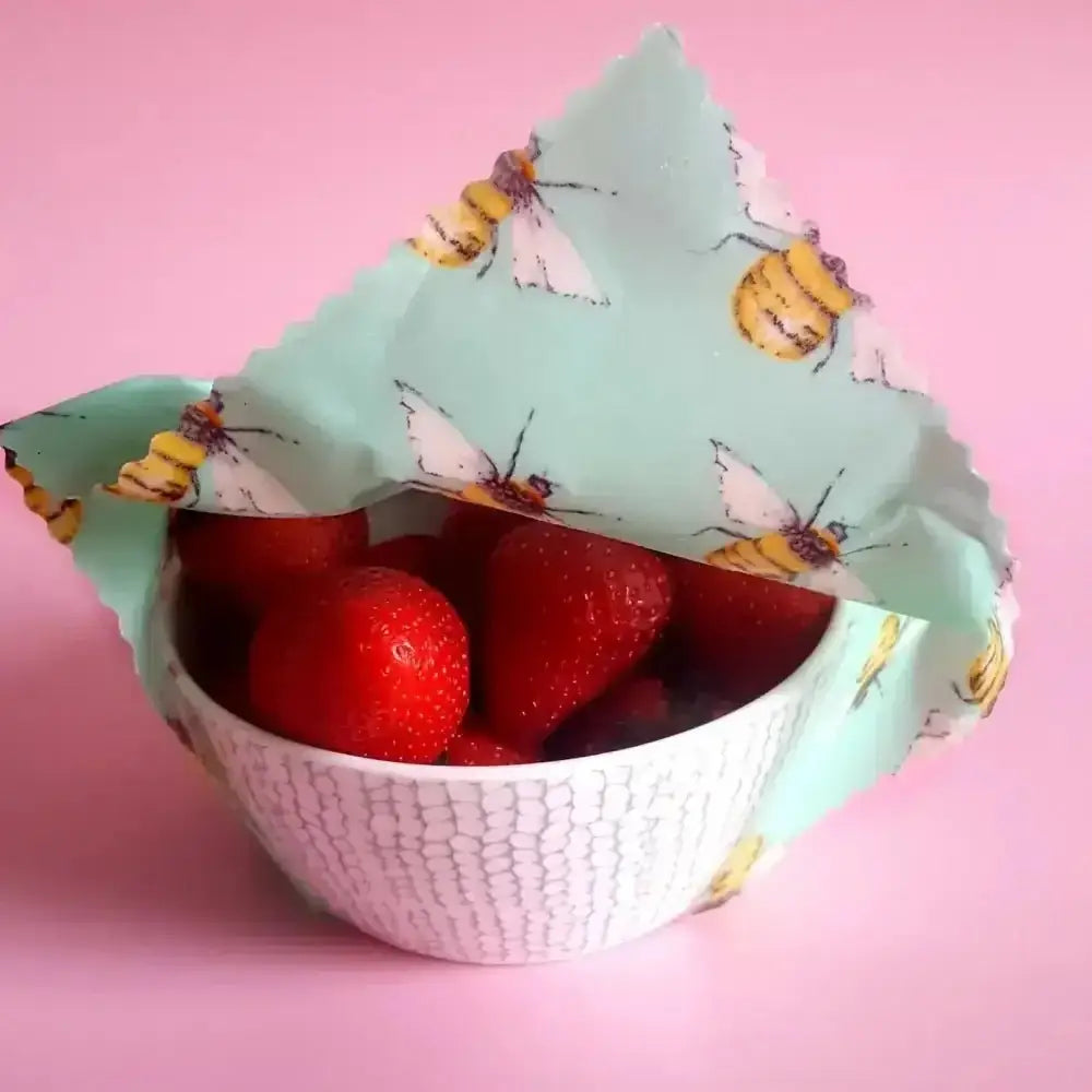 Honey Bee Good’s mint green beeswax wrap with bee design for strawberries