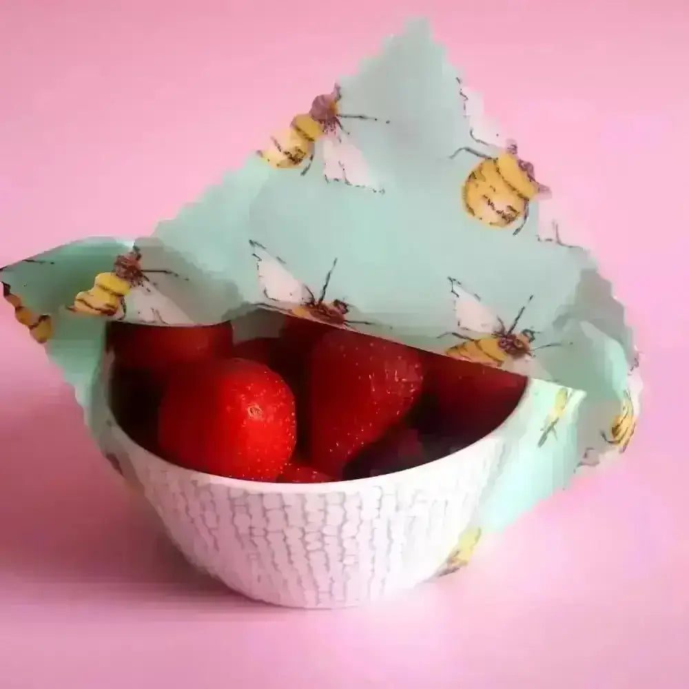 Honey Bee Good’s mint green beeswax wrap with bee design for strawberries