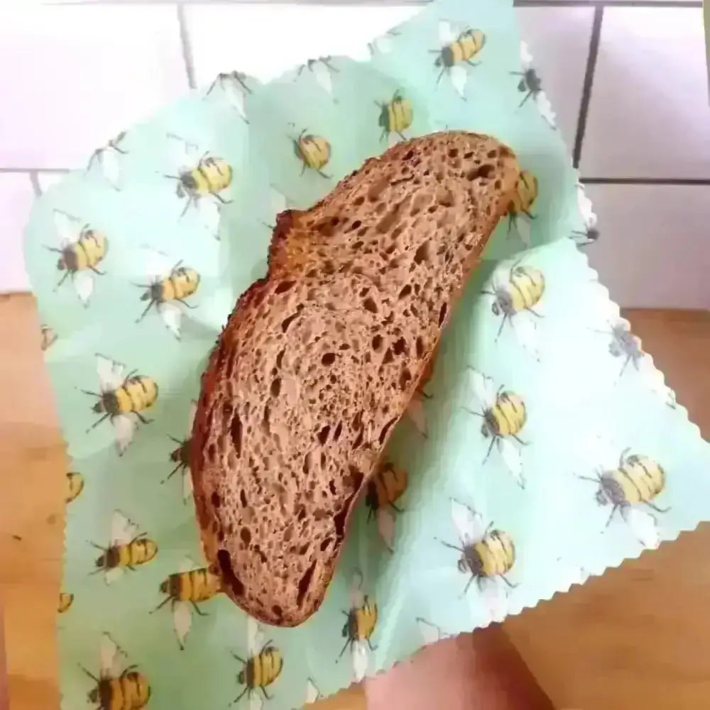 Dark brown artisan bread slice on Honey Bee Good’s eco-friendly bee-patterned wrap