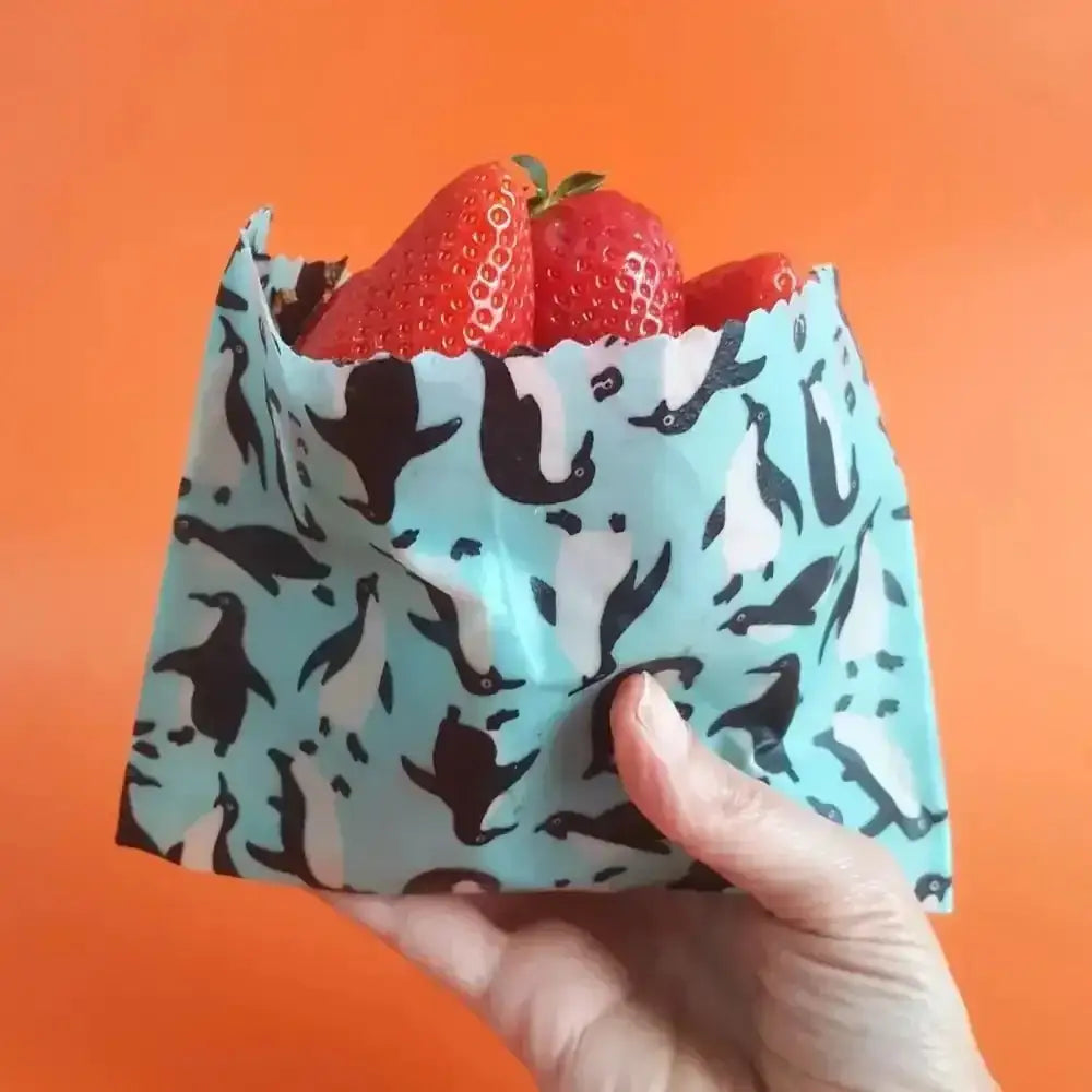 Teal penguin snack bag with strawberries in Honey Bee Good’s eco wraps