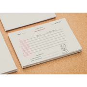 White dog-themed FREE TEDDY puppy training tracker notepad with pink accents