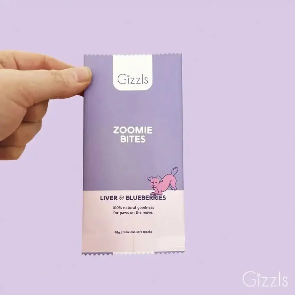 Gizzls Zoomie Bites purple dog treat bag with pink pig illustration
