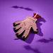 Pink hand toy with black accents and a skeleton hand on a purple background