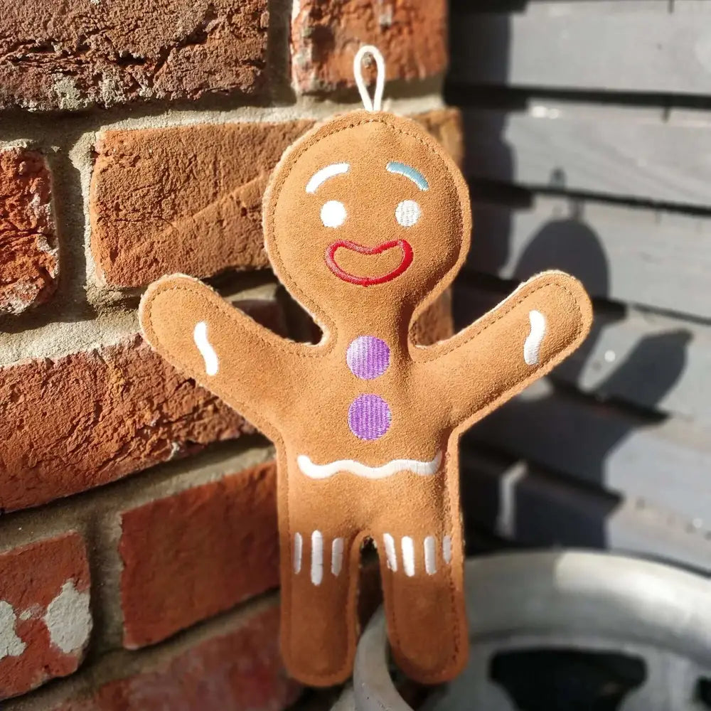 Green And Wilds Jean Genie gingerbread plush toy on brick wall
