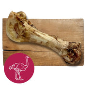 Ostrich bone cutting board with natural wood finish and white ostrich graphic on pink background